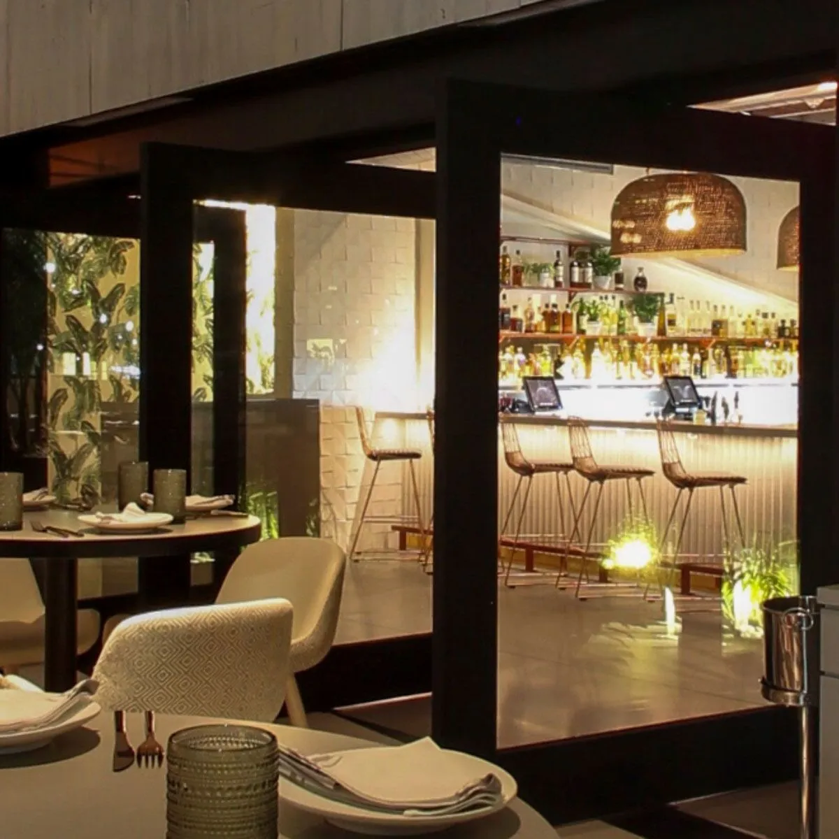 A pivot door in a black paint finish, installed in a restaurant bar.