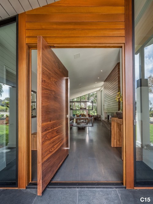 Horizontal Grain Flat Pivot Door made out of Walnut hardwood with a Square Pull Bar